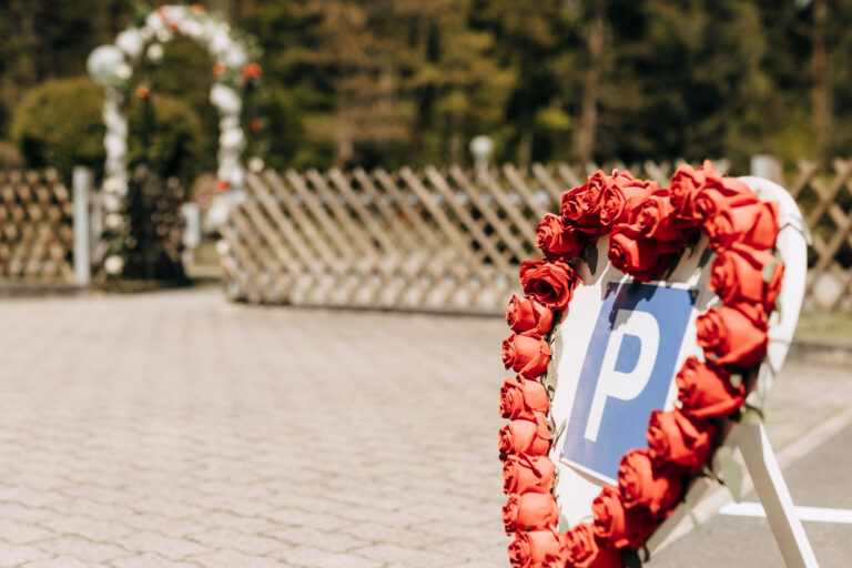 Hotel Silberbach Hochzeit Blumenkranz aus roten Rosen vor Parkbereich
